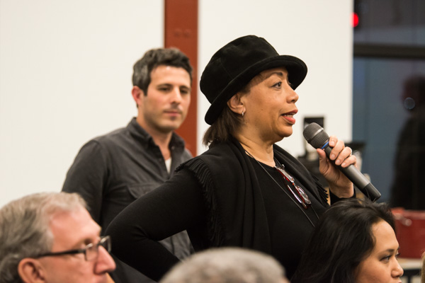 An audience member asks the panelists a question
