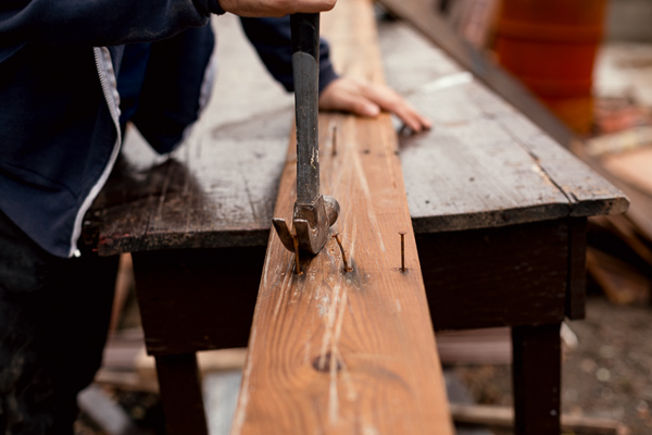 Dubay removes nails from scrapped wood, making them useable again